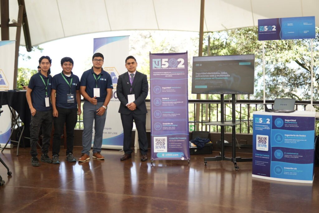 Integrantes de NT502 en el stand junto al pendón de servicios y el mostrador con código QR.